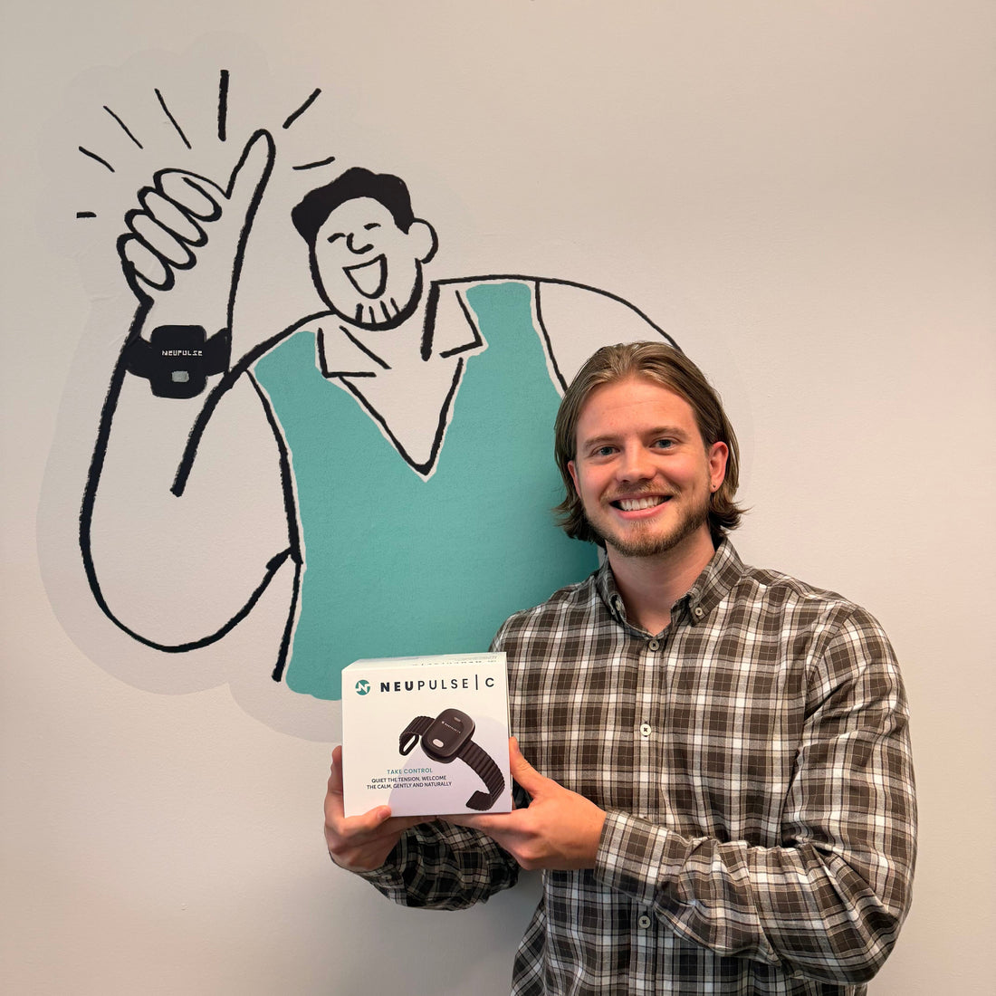 Man holding Neupulse box and smiling in front of Steve the Neupulse mascot 